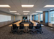 Thumbnail 6 of 18 - A conference room with a long table and chairs.