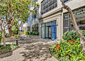 Thumbnail 1 of 25 - A building with a tree in front of it.