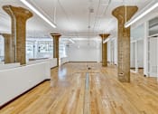Thumbnail 7 of 25 - A room with wooden floors and pillars.