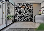 Thumbnail 23 of 25 - A glass door with a black and white tree design on the wall behind it.