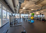 Thumbnail 16 of 24 - A gym with a view of the city outside the windows.