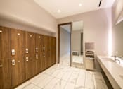 Thumbnail 17 of 24 - A bathroom with a row of wooden lockers and a marble floor.