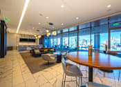 Thumbnail 20 of 24 - A large round wooden table is surrounded by chairs in a room with a marble floor.