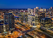 Thumbnail 23 of 24 - A cityscape at night with illuminated buildings and roads.