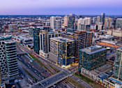 Thumbnail 2 of 24 - A cityscape with tall buildings and a highway.
