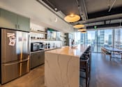 Thumbnail 8 of 24 - A modern kitchen with a marble island and stainless steel appliances.