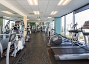 Thumbnail 4 of 18 - A gym with treadmills and elliptical machines.