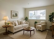 Thumbnail 6 of 8 - A living room with a couch, chair, and table.