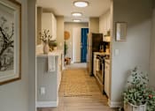 Thumbnail 4 of 8 - A kitchen with a blue refrigerator and wooden floors.