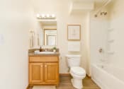 Thumbnail 4 of 8 - A white toilet sits next to a sink in a bathroom.