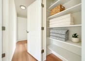 Thumbnail 1 of 8 - A white bathroom with a towel and a plant on the shelf.