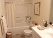 Thumbnail 3 of 8 - A white bathroom with a towel hanging on the towel rack.