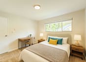Thumbnail 2 of 8 - A bedroom with a bed, desk, and chair.