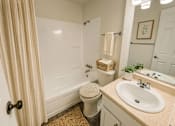 Thumbnail 7 of 8 - A bathroom with a toilet, sink, and shower.