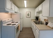 Thumbnail 3 of 8 - A kitchen with white cabinets and a stove top oven.