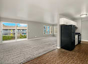 Thumbnail 7 of 8 - A black refrigerator sits in a kitchen next to a window.