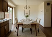 Thumbnail 1 of 8 - A dining room with a table set for four.