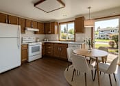 Thumbnail 5 of 8 - A kitchen with white appliances and wooden cabinets.