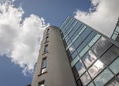 Thumbnail 2 of 7 - the side of a tall building with clouds reflected in the windows