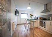 Thumbnail 7 of 8 - a kitchen and dining area with a table and chairs