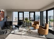 Thumbnail 12 of 19 - a living room with a view of a city and a table and chairs