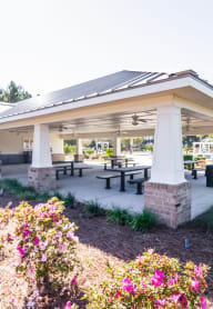 a covered patio with tables and benches in a pavilion