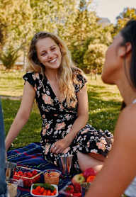 three women sitting at a picnic in the park