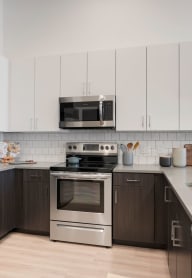 a kitchen with white cabinets and stainless steel appliances