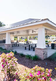 a covered patio with tables and benches in a pavilion