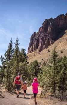 a family walks along a trail in the mountains
