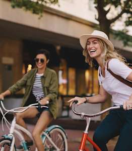 Two people riding bicycles in an urban setting.