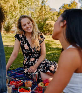 Three women having a picnic in a park.