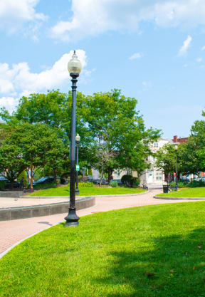 a park with green grass and a brick walkway