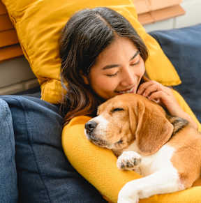 a woman sleeping on a couch with her dog