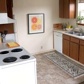 A kitchen with a stove top oven and a sink.