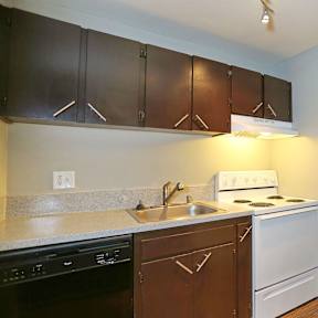 A kitchen with brown cabinets and white appliances.