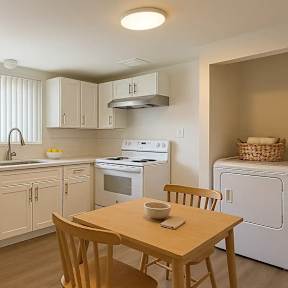 A kitchen with a table and chairs.