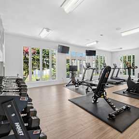 A spacious gym with a variety of equipment including treadmills, stationary bikes, and weight machines.