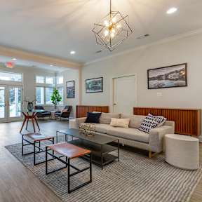 A living room with a grey couch and a wooden coffee table.