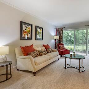 A living room with a couch, chair, and television.