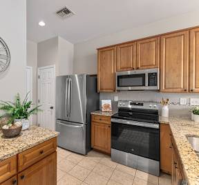 A kitchen with granite countertops and wooden cabinets.