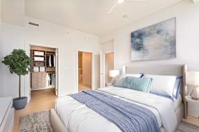 A bedroom with a large bed and a painting on the wall.