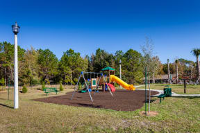 a playground with a large yellow slide in the middle of a grassy area