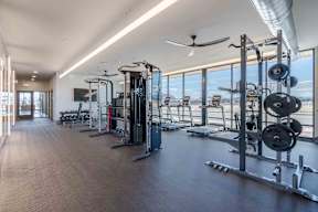 A spacious gym with a variety of equipment and a view of the outside.