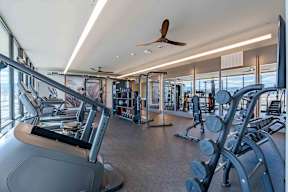 A gym with treadmills, weights, and exercise equipment.