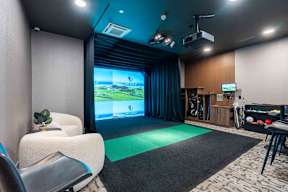 A room with a large screen and a green mat in front of it.