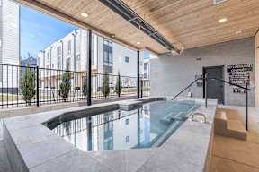 A pool with a black fence and a sign that says no lifeguard on duty.