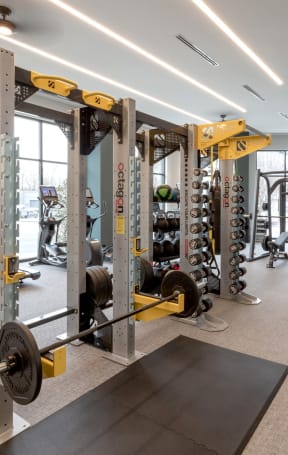 a gym with weights and other equipment in a building with windows