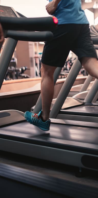 A group of people are exercising on treadmills in a gym.