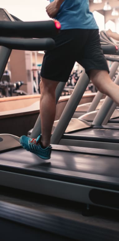 a man running on a treadmill in a gym